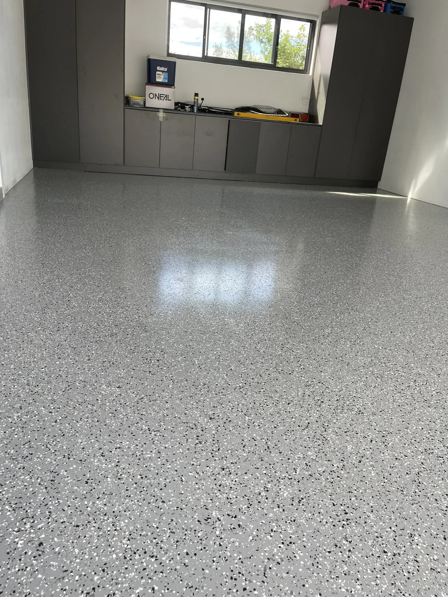 Glossy flake epoxy floor with cabinets along the back wall