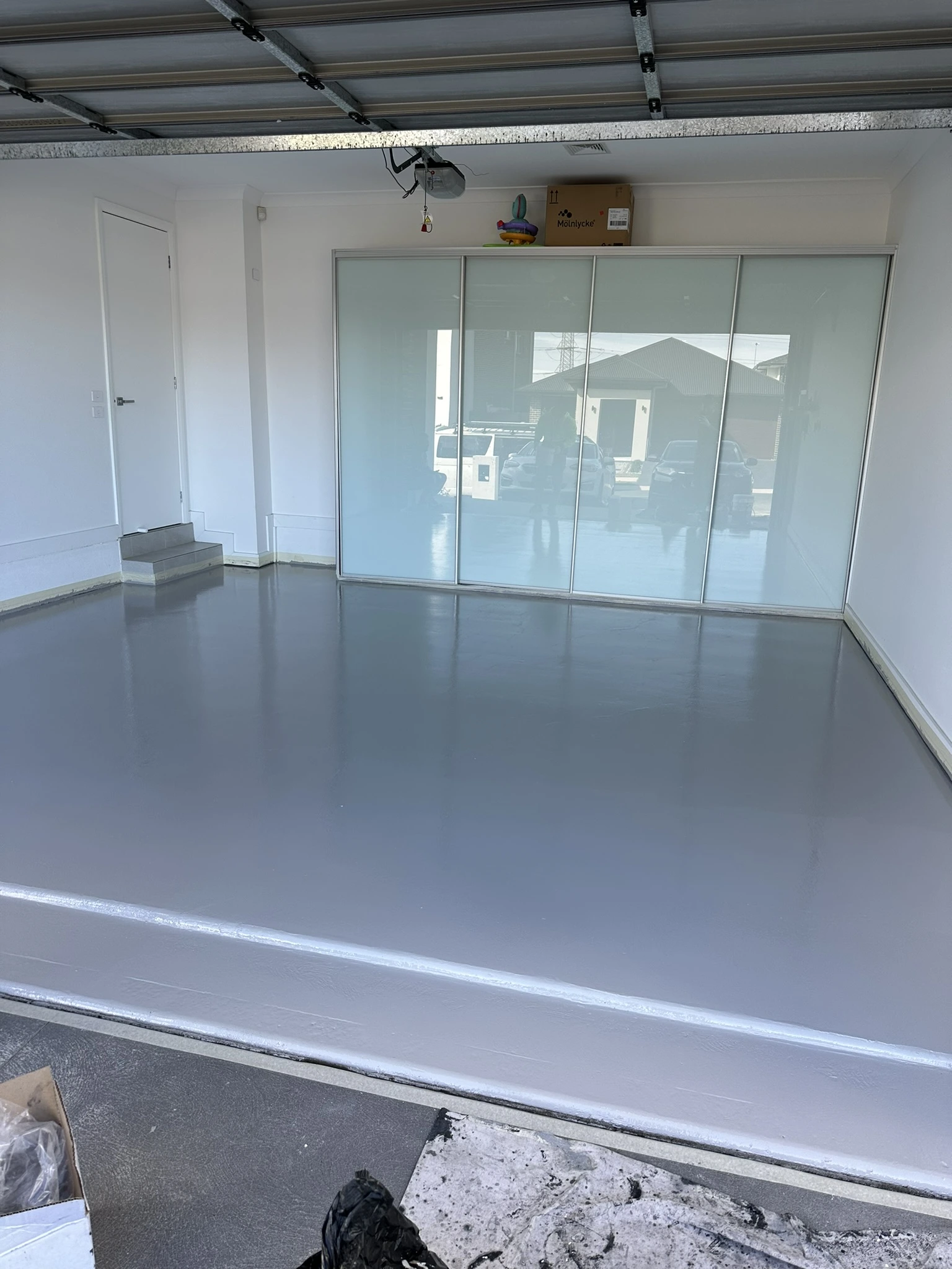 Glossy grey epoxy floor with sliding glass doors