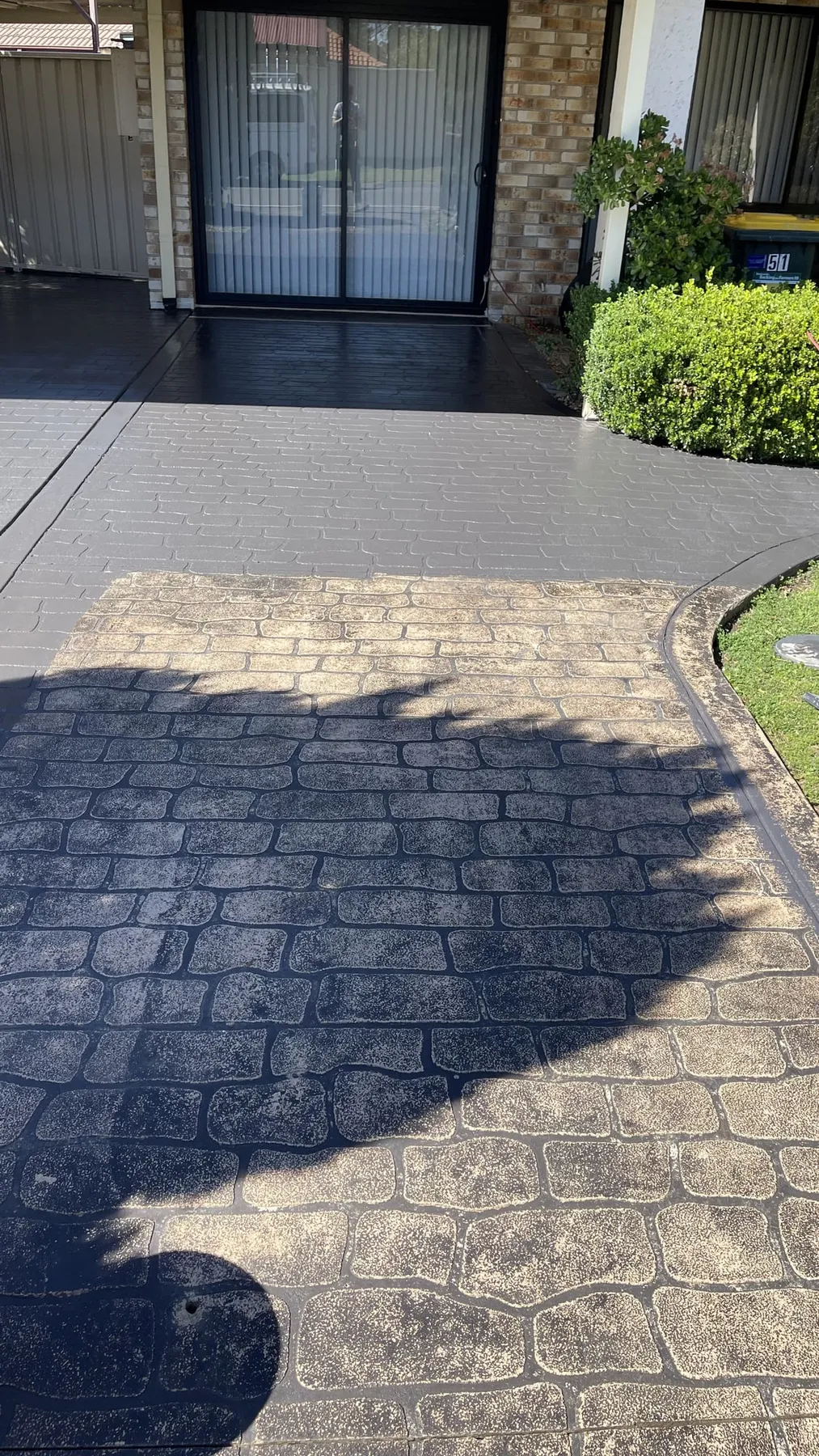 Weathered cobble-pattern concrete at the front door before sealing