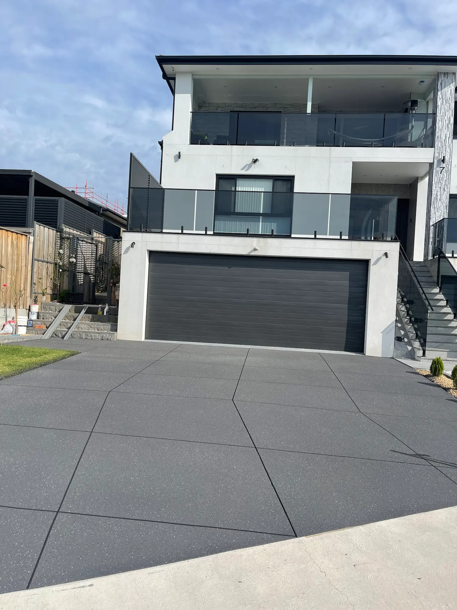 Gunmetal spray-crete driveway with a large box pattern on a modern Western Sydney home
