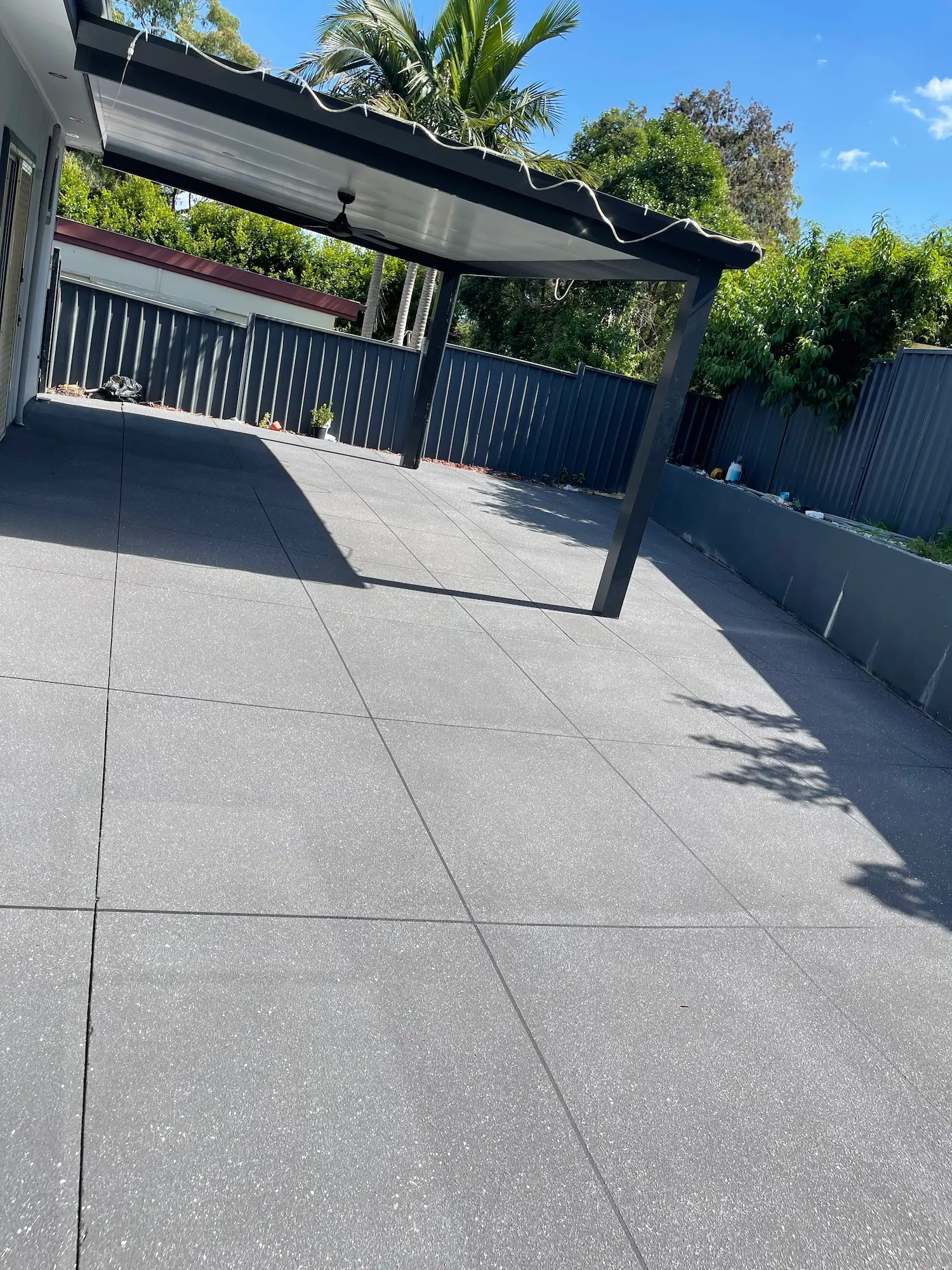 Charcoal spray-crete under a carport