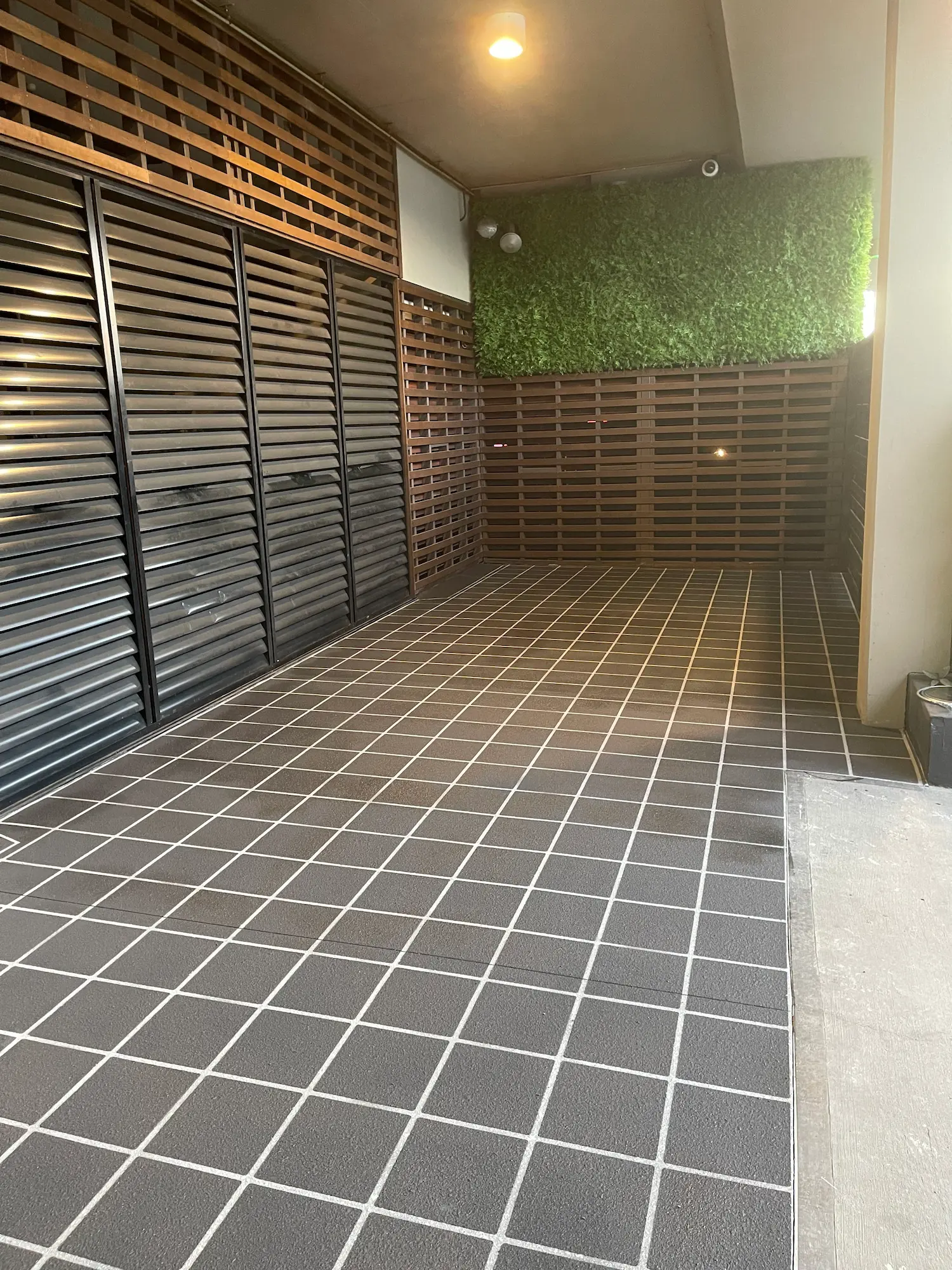 Tile-pattern spray-crete courtyard with timber screen walls